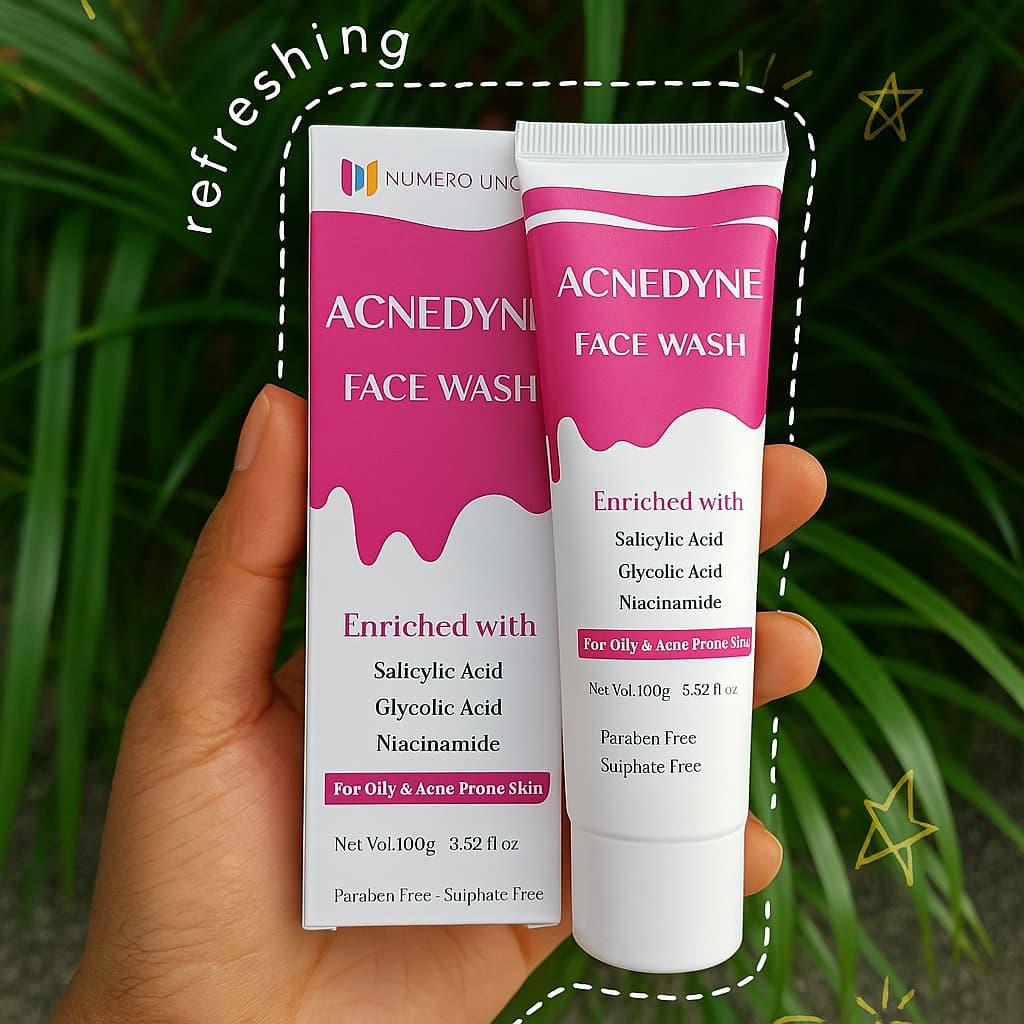 Acnedyne face wash packaging held in a hand with green leaves in the background