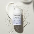 Contrast M Melasma Cream bottle on white and clear cream swirls with water droplets